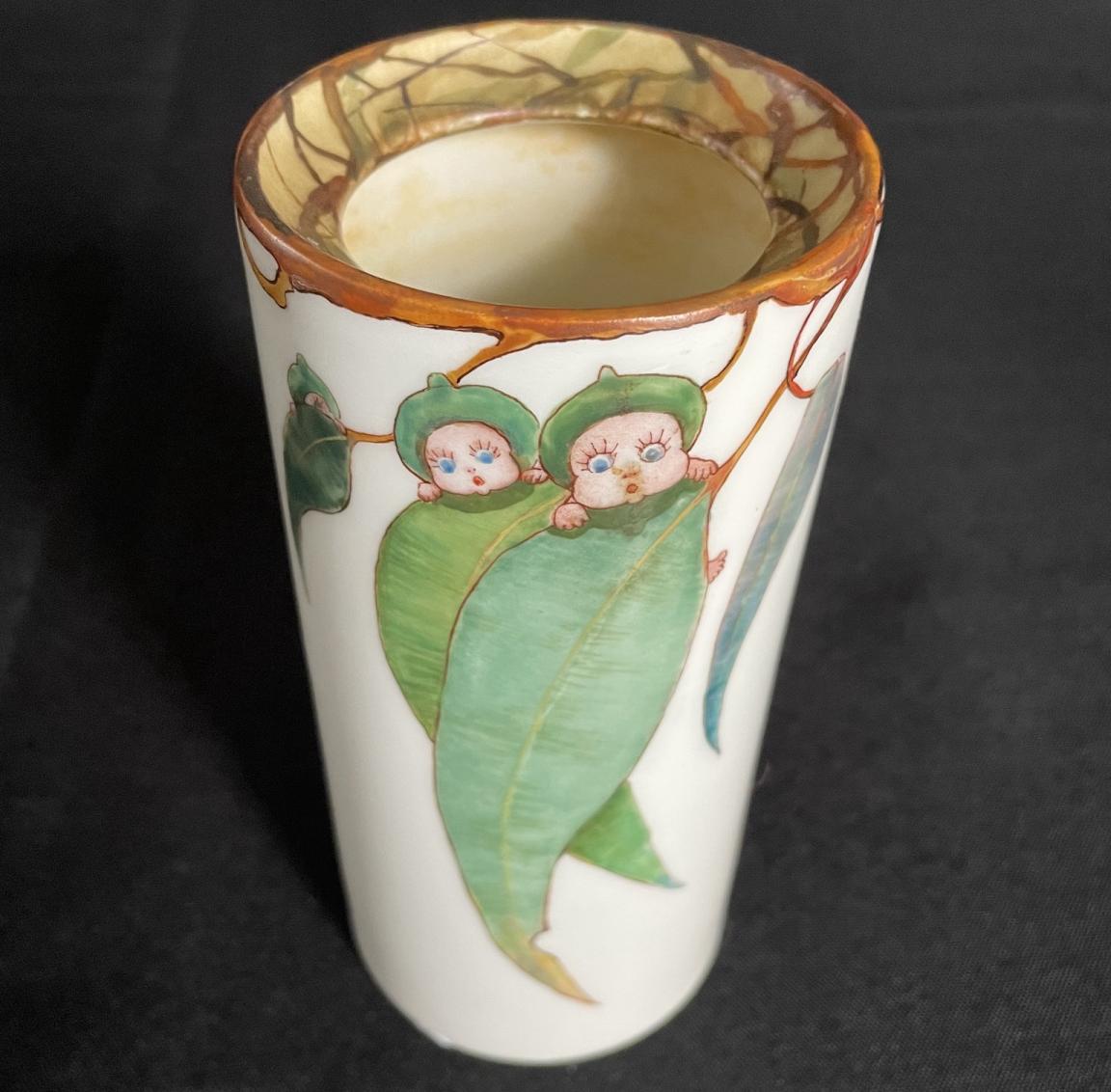 Small white, opaque vase painted with 'gumnut baby' characters