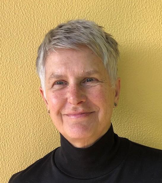 Woman, Helen Ennis, Standing in front of a yellow wall smiling