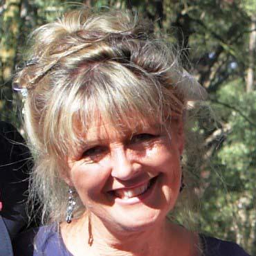Photo of a smiling blonde woman with sun and shade on her face 