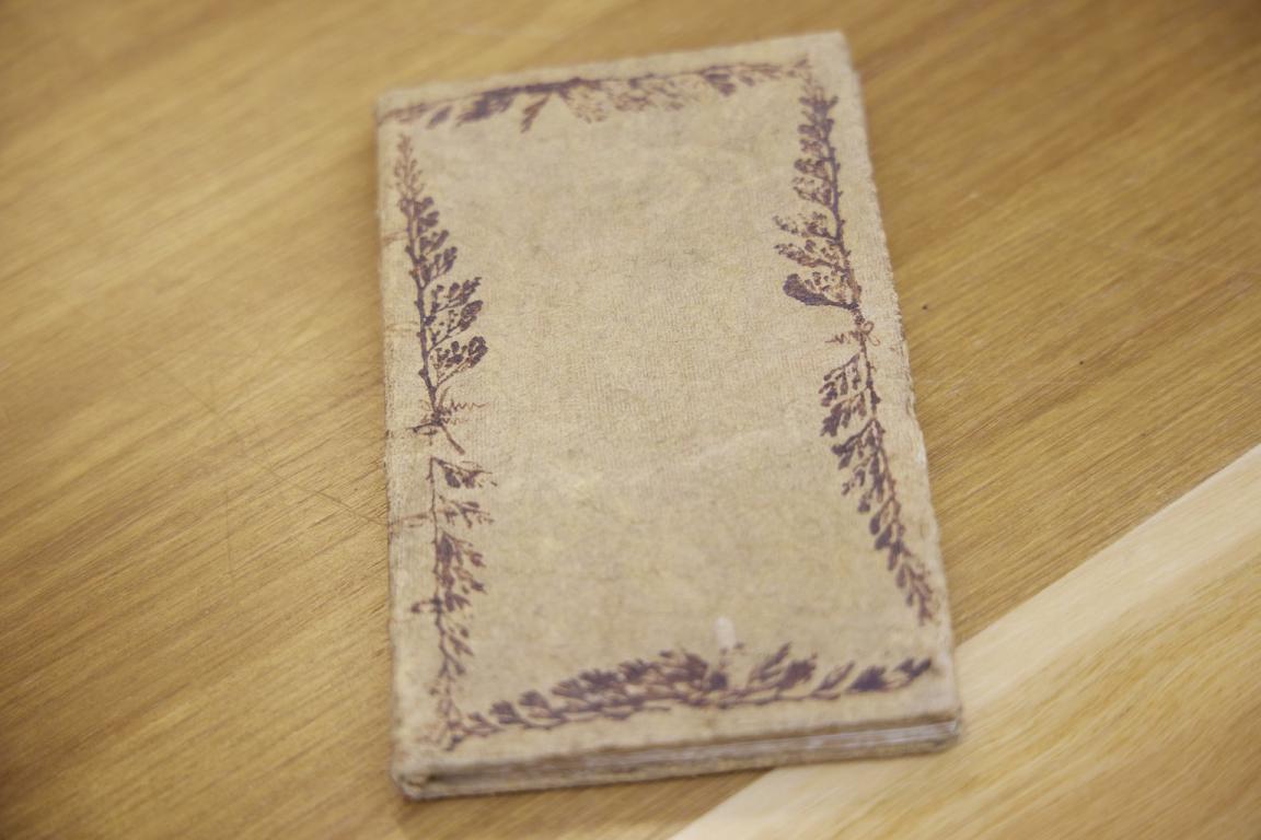 Old book bound in tapa cloth and decorated with a red leaf design