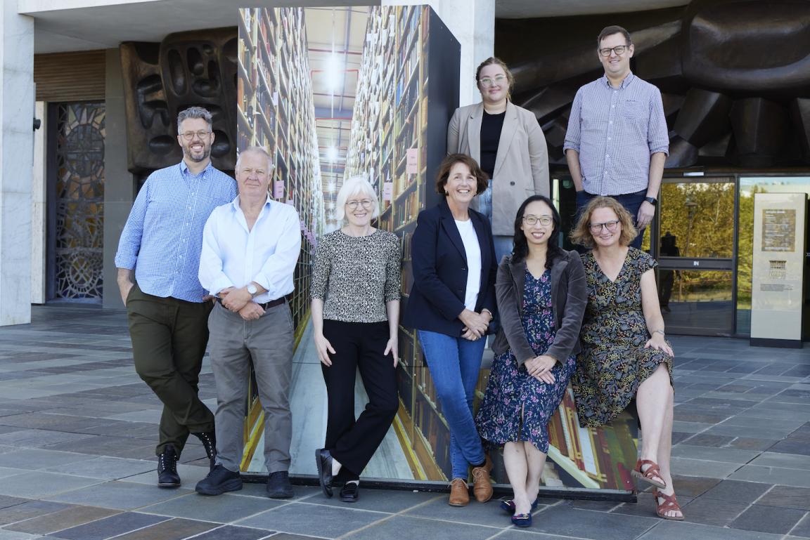 Group of men and women, standing and sitting together on the National Library podium