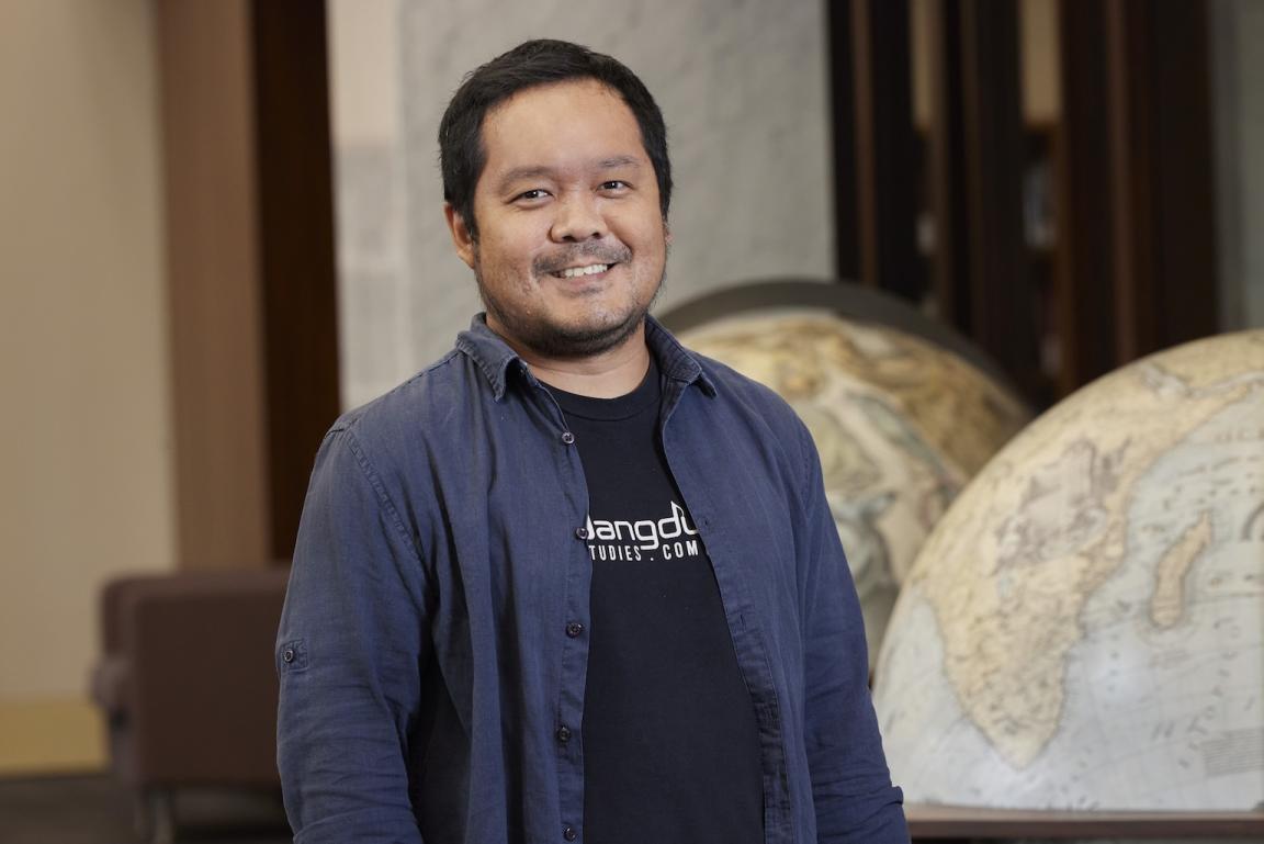 Michael Raditya standing in the Main Reading Room and smiling