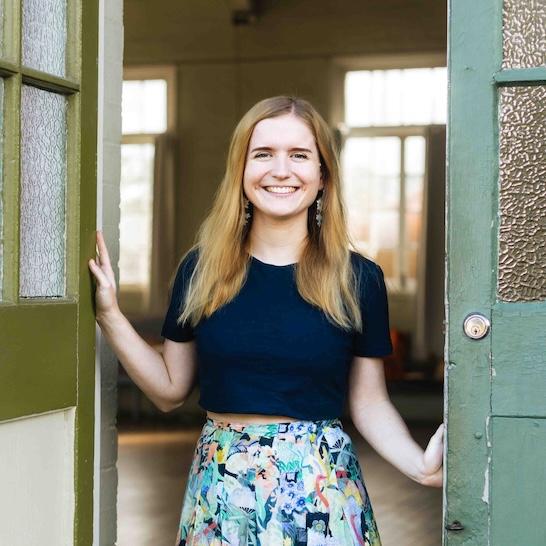 Illustrator Ingrid Bartkowia standing in a doorway smiling
