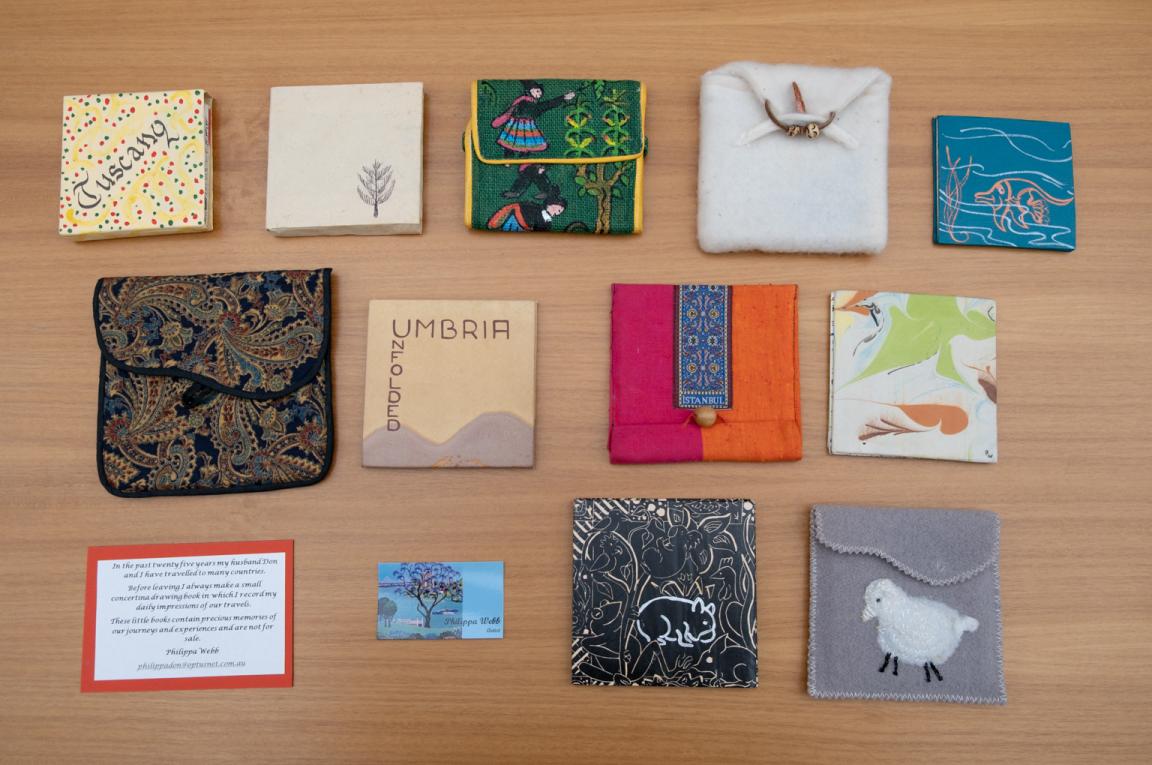 Small handmade diaries of various sizes and designs, some in fabric cases