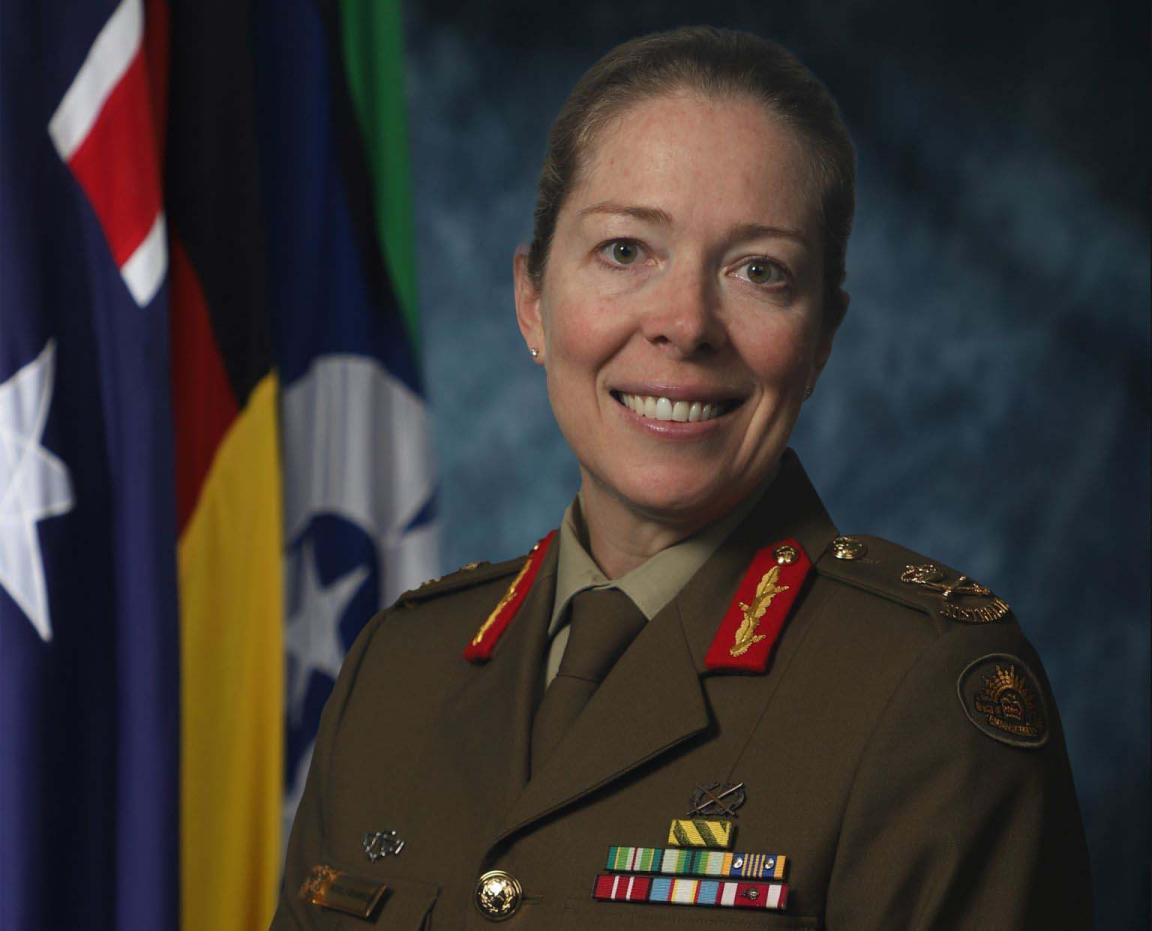 A smiling woman dressed in military clothing
