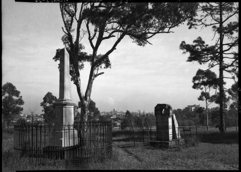 Two pillars in a park barricaded by fences.