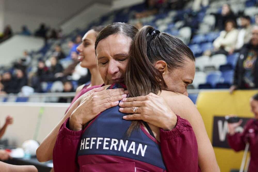 Two women hugging at a netball tournament