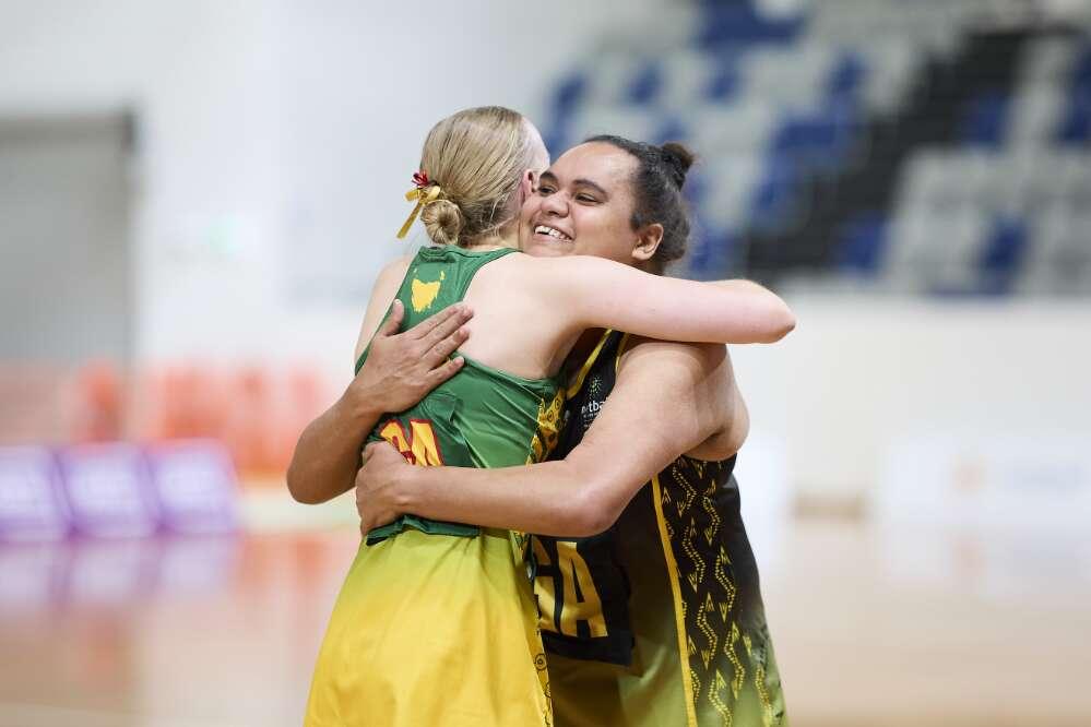 Two female netball players hug