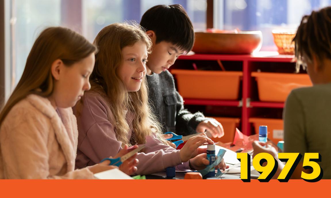 Children seated at a table doing craft activities