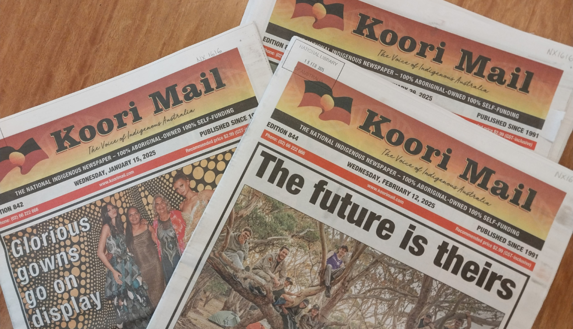 Three 2025 editions of 'Koori Mail' spread on a wooden desk