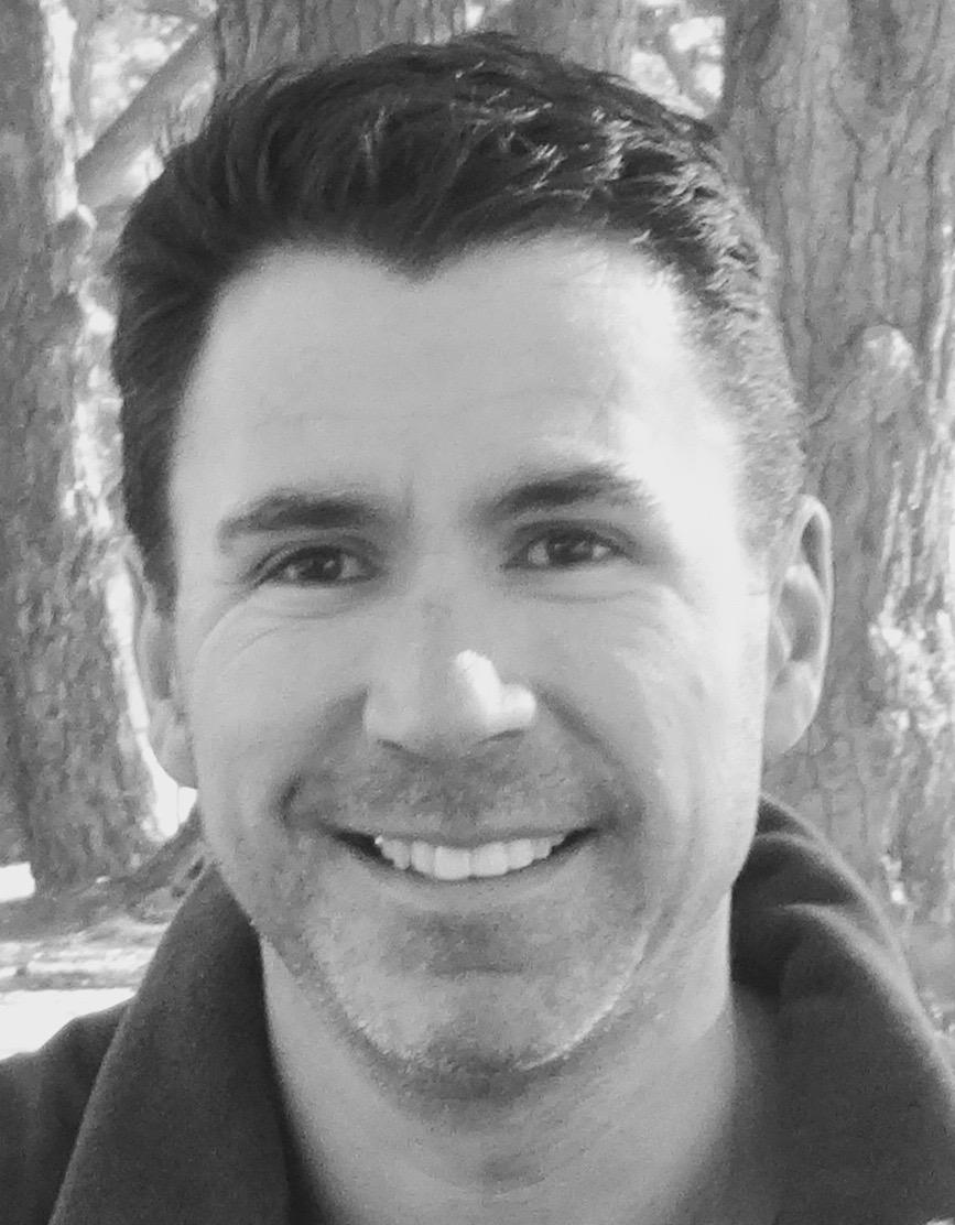 A close up black and white photo of author Daniel Oakman