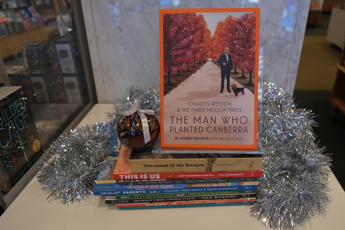 An illustrated book cover featuring a man and dog pictured in front of trees in autumn colour