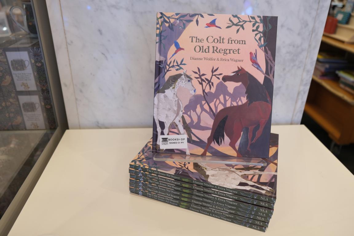 An illustrated book with a horse on the cover, sitting atop a stack of the same book