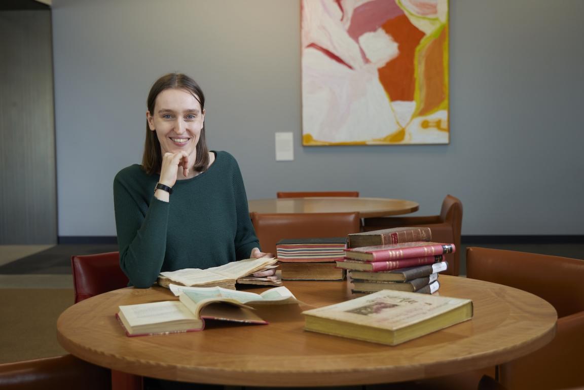 Dr Jorien van Beukering sitting at a table with books across it.