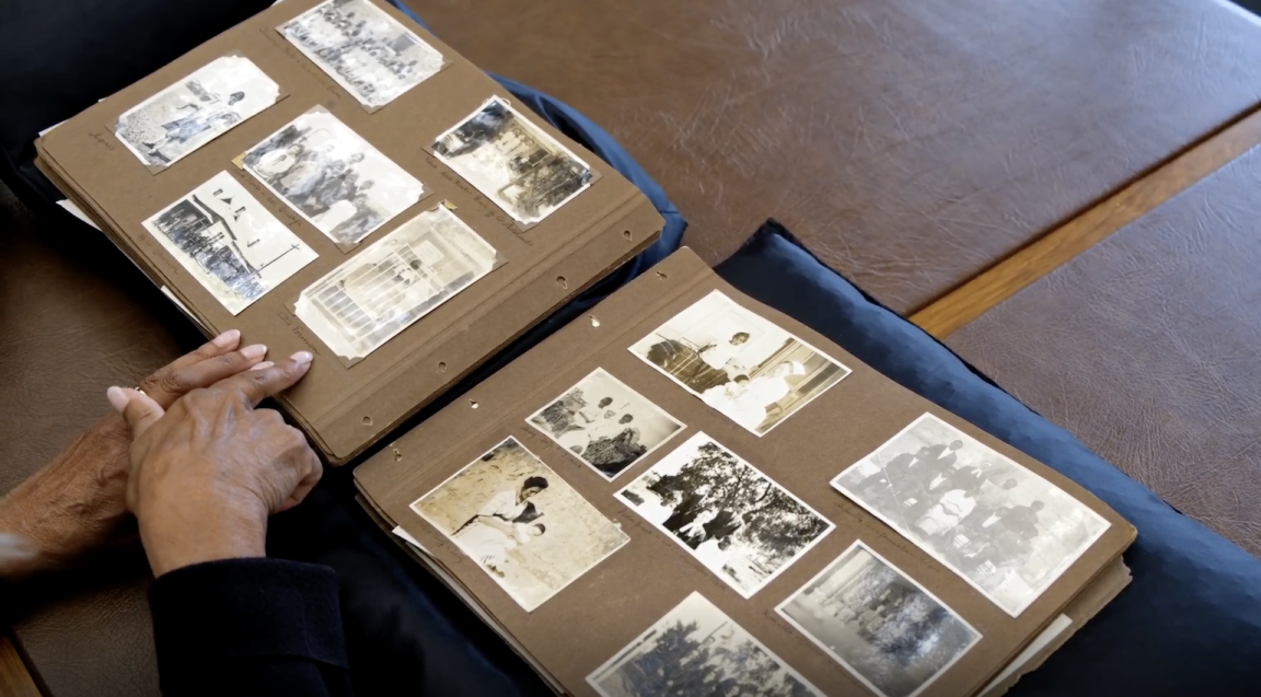 Wirangu Elder, Sandra Miller looking at a photo album and pointing at a piicture of a relative