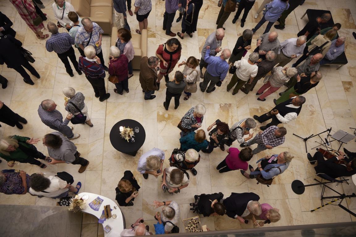 Lots of people standing and chatting in the Library foyer for an event