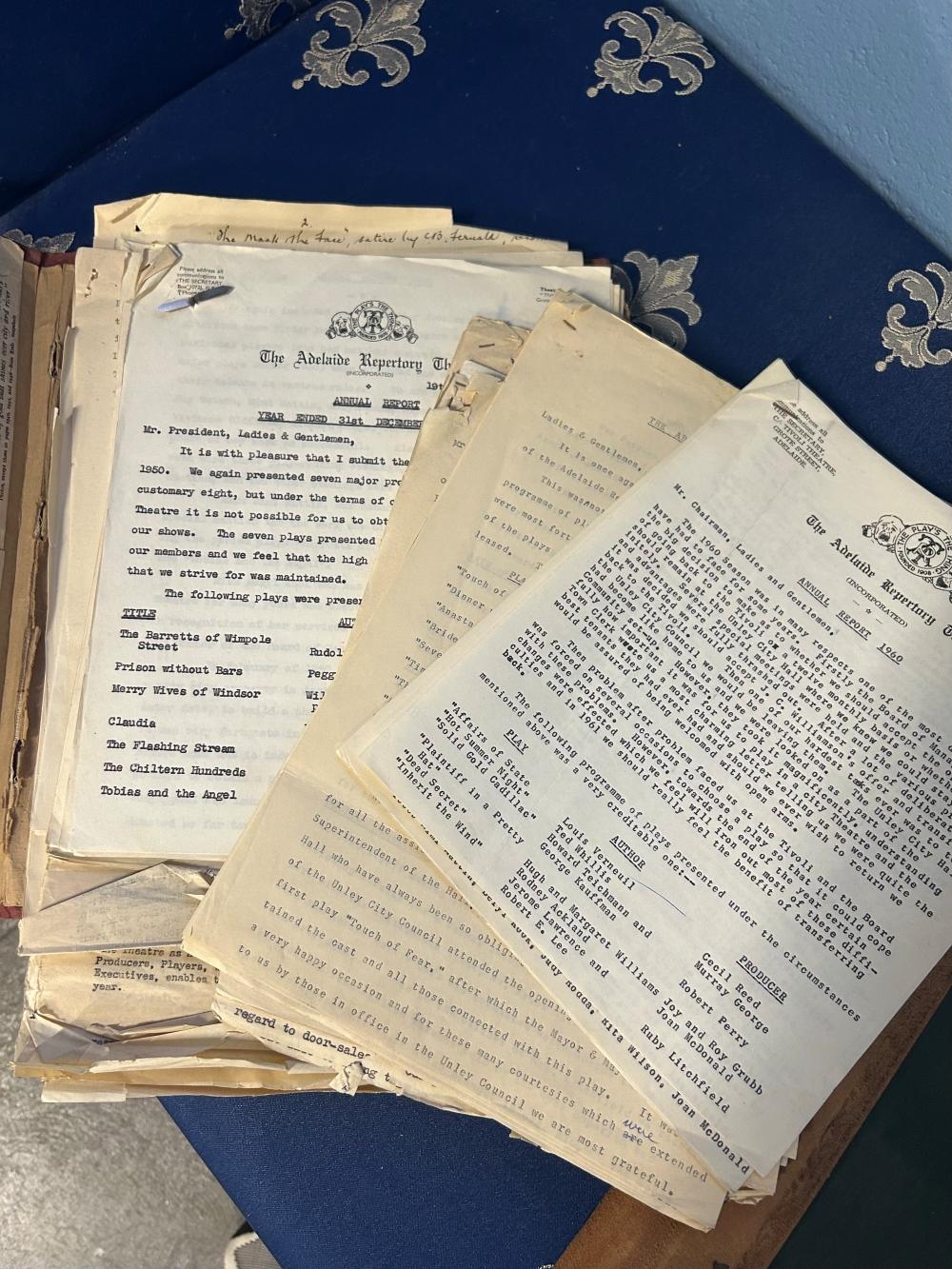 A stack of old papers and reports spread over a desk.