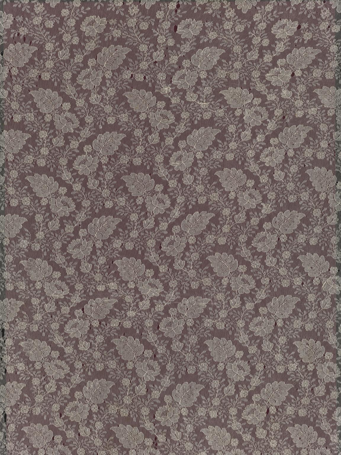 Machine lace wedding veil photographed on a burgundy background.