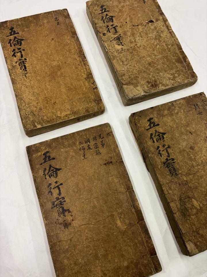 Four old books lie on a table.