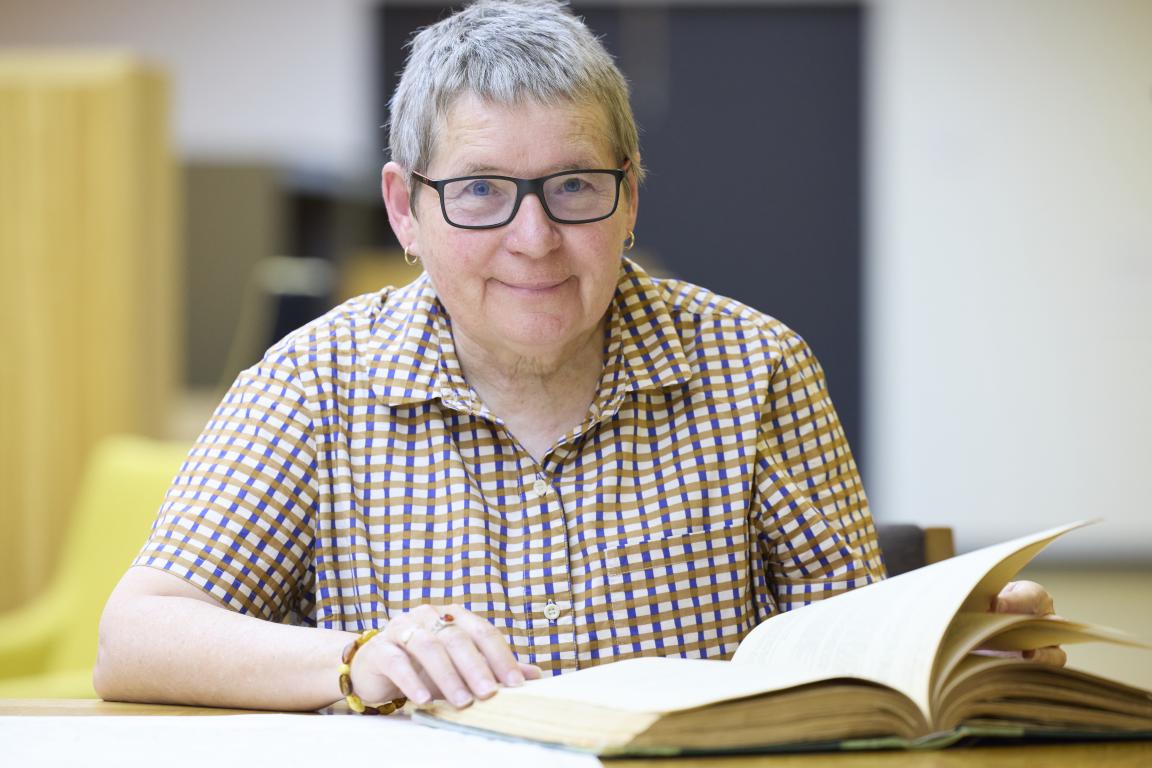 A woman smiling with collection material in the National Library's Special Collections Reading Room