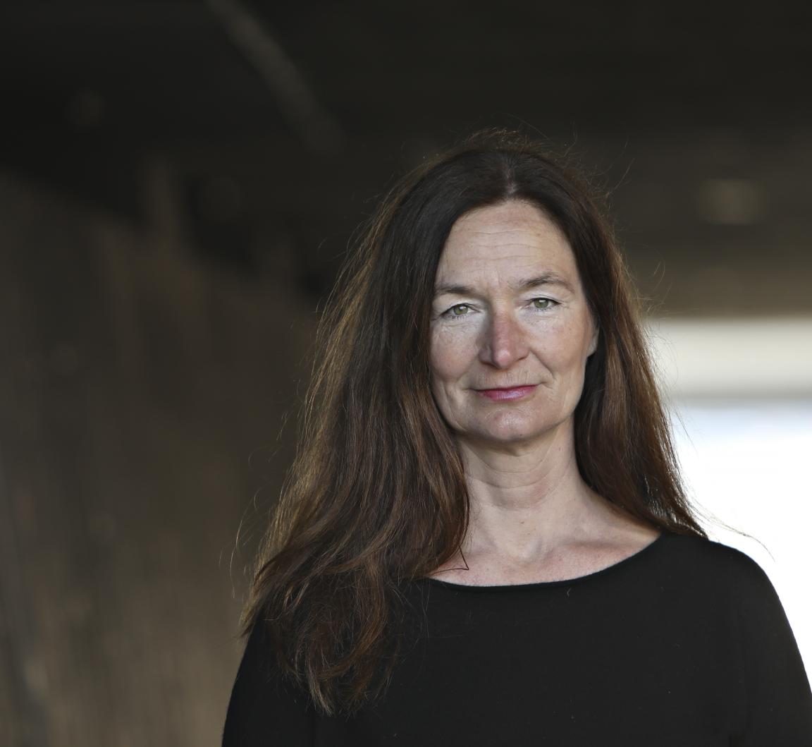 A woman with long dark hair wearing a black t-shirt