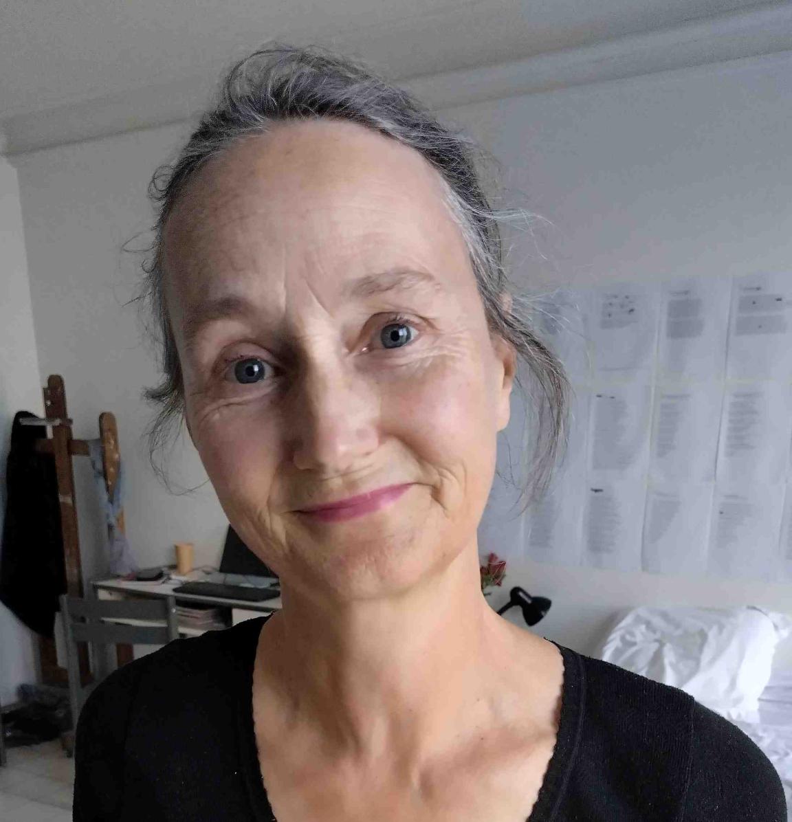 A woman with her hair tied back, wearing a black shirt