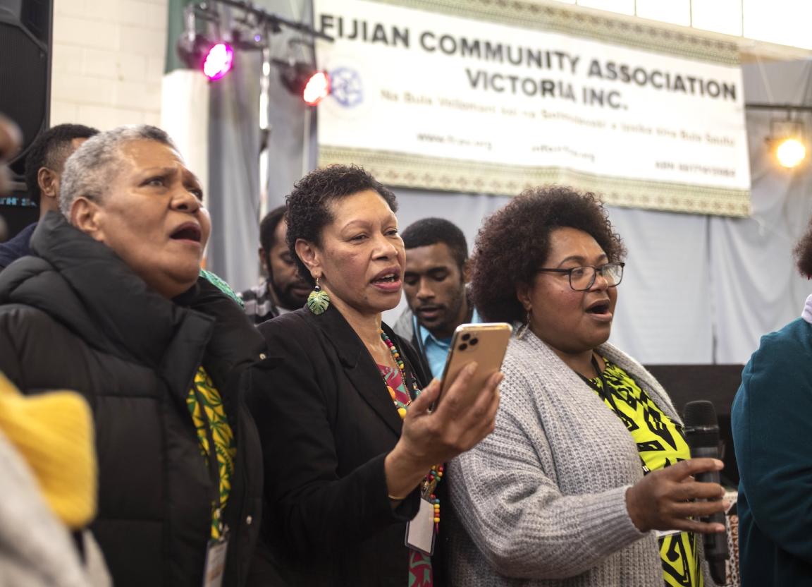 Three women, part of a choir, singing at the Fiji Tauvu Festival 2022
