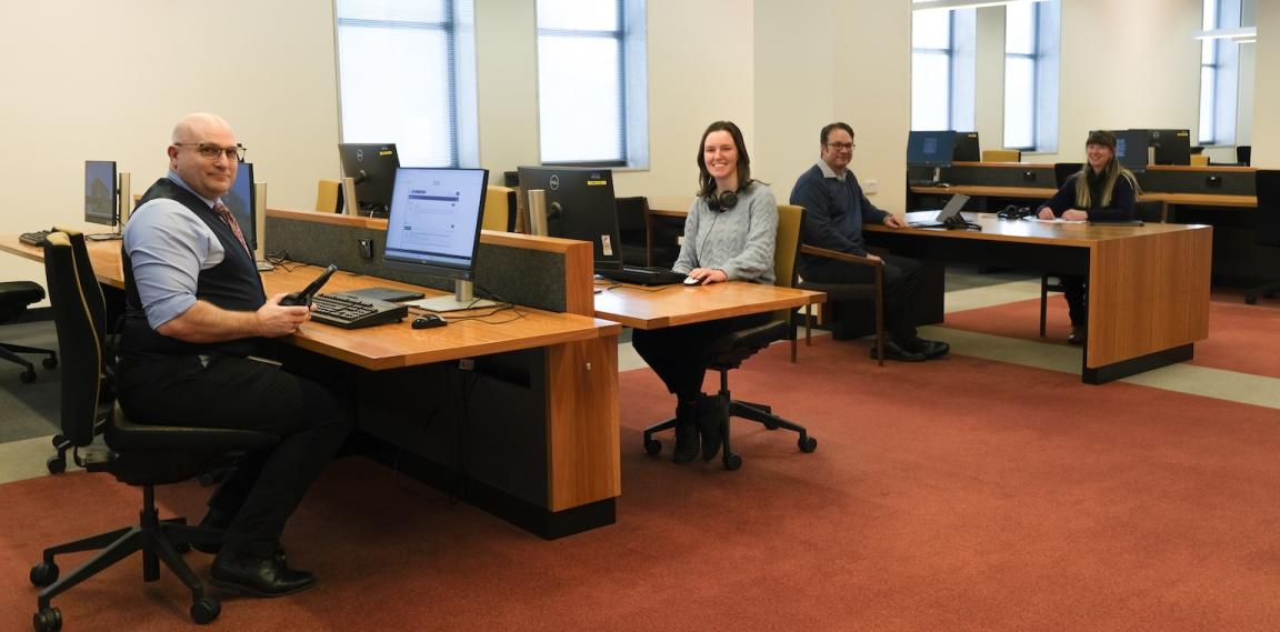 Four members of the Library's Special Collections Research & Support team, two men and two women, sitting at tables in the Main Reading Room