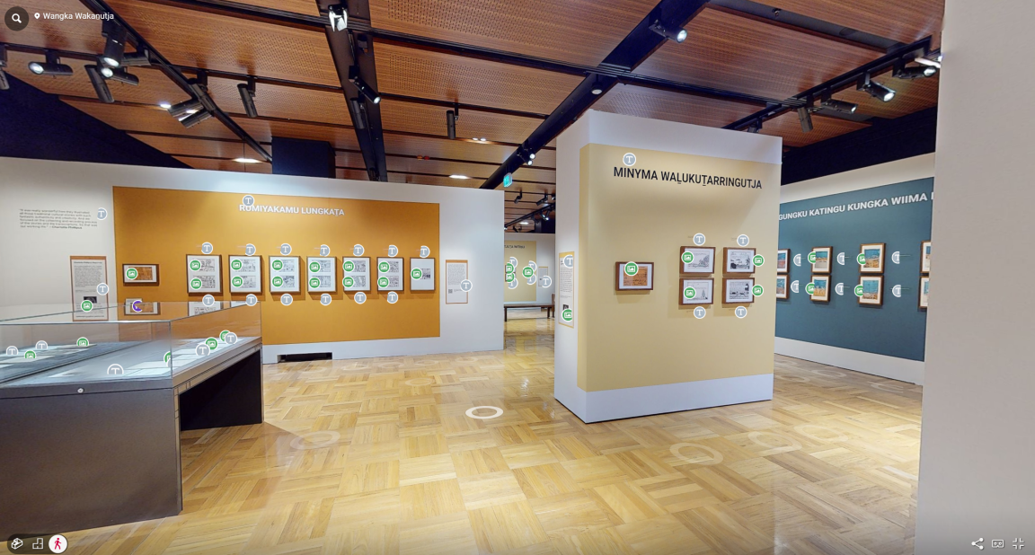 A wide-angle view inside an exhibition gallery. The walls feature illustrations and photographs with descriptive text.