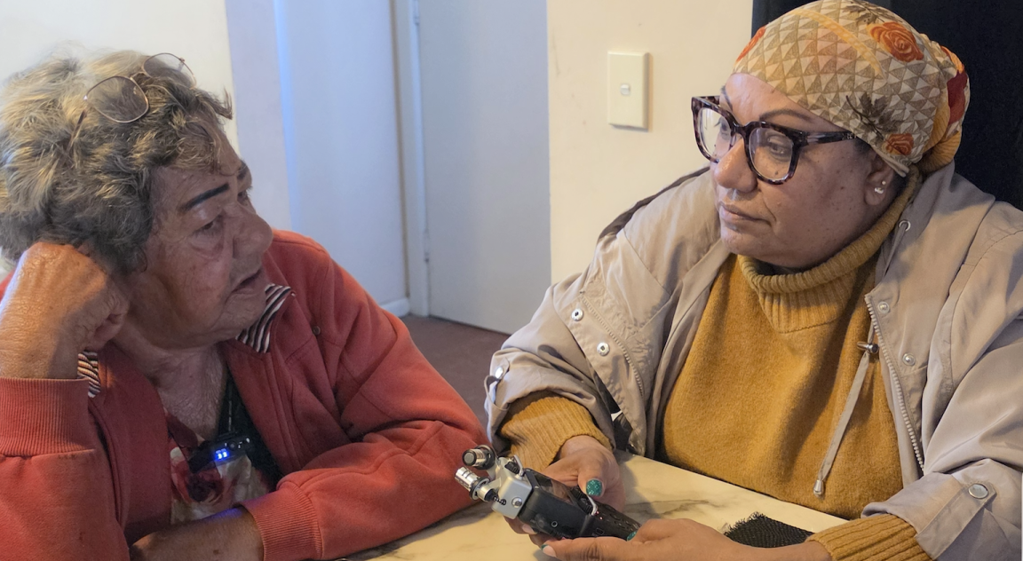 Two First Nations women sitting at a table conducting an oral history interview.