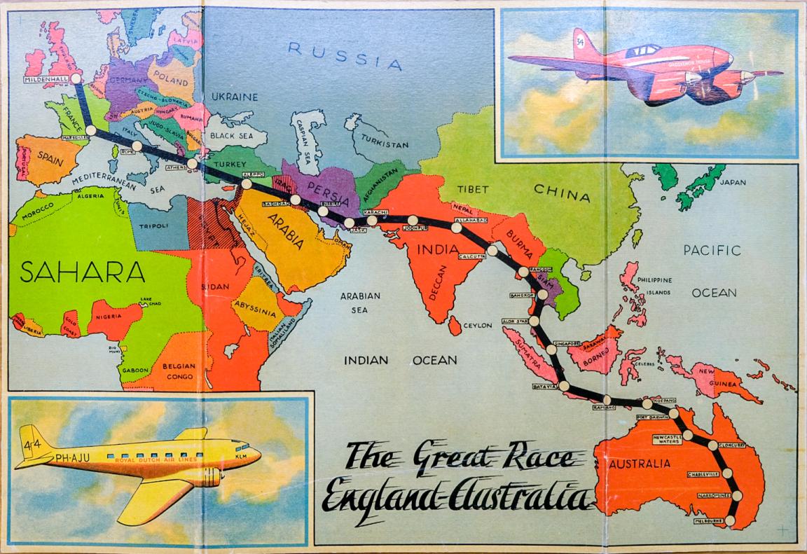 Colourful board game where the board shows a vibrant world map, with a black line depicting the path of participants of the MacRobertson International Air Race from London to Melbourne