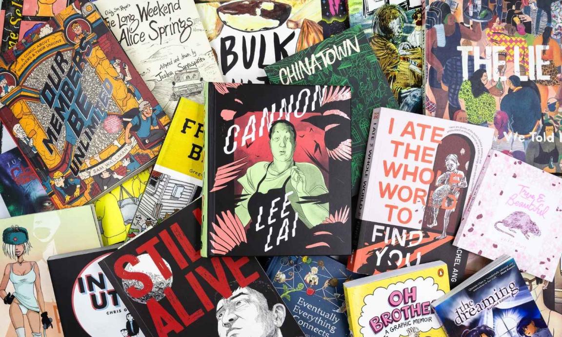A pile of comics and graphic novels scattered over a table