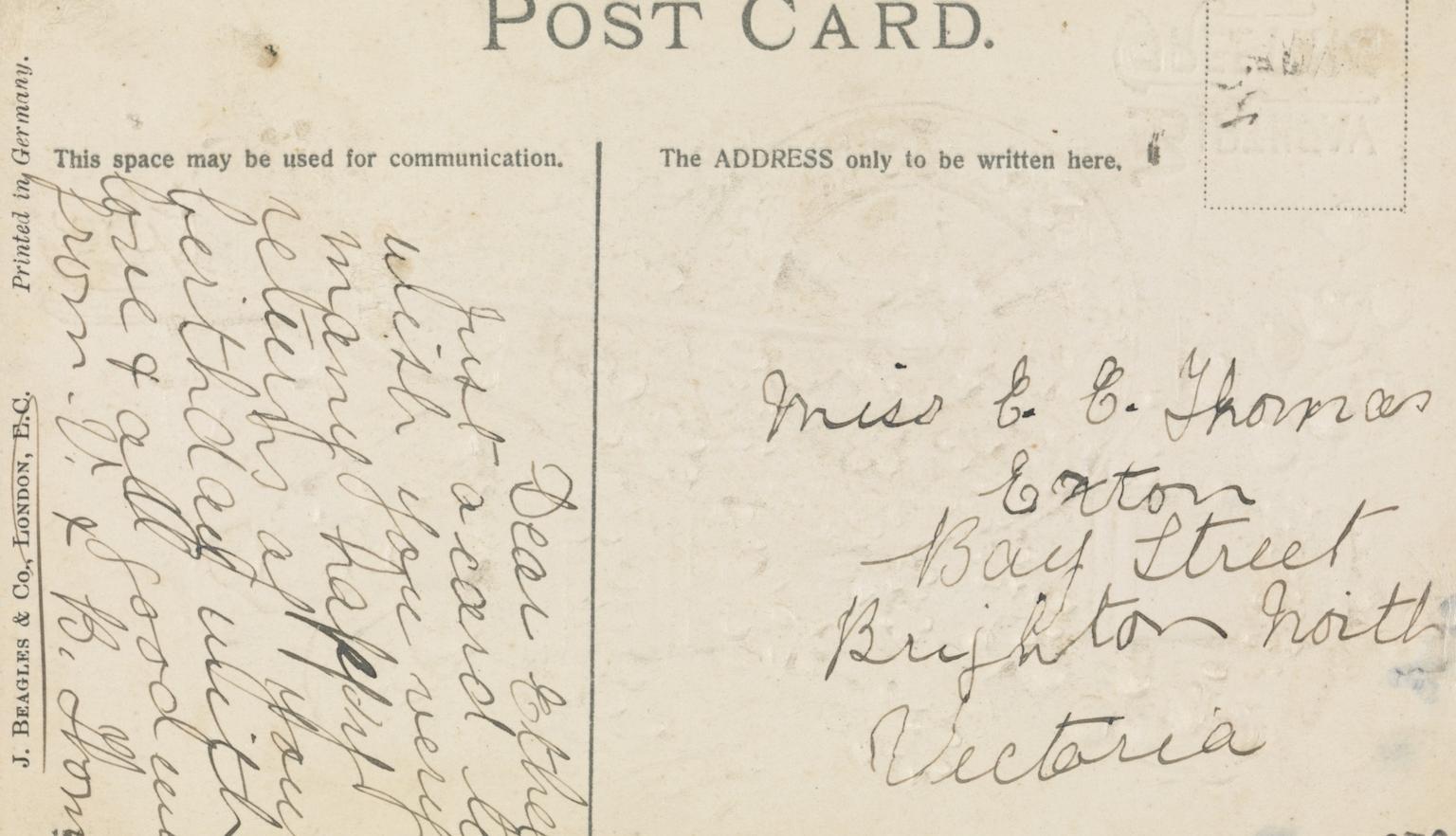 Back of an old postcard with a message wishing the recipient many happy returns.