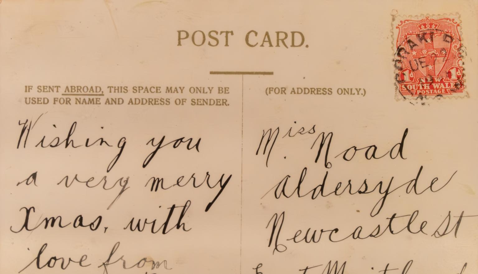 Back of an old postcard with a message wishing the recipient a merry Christmas