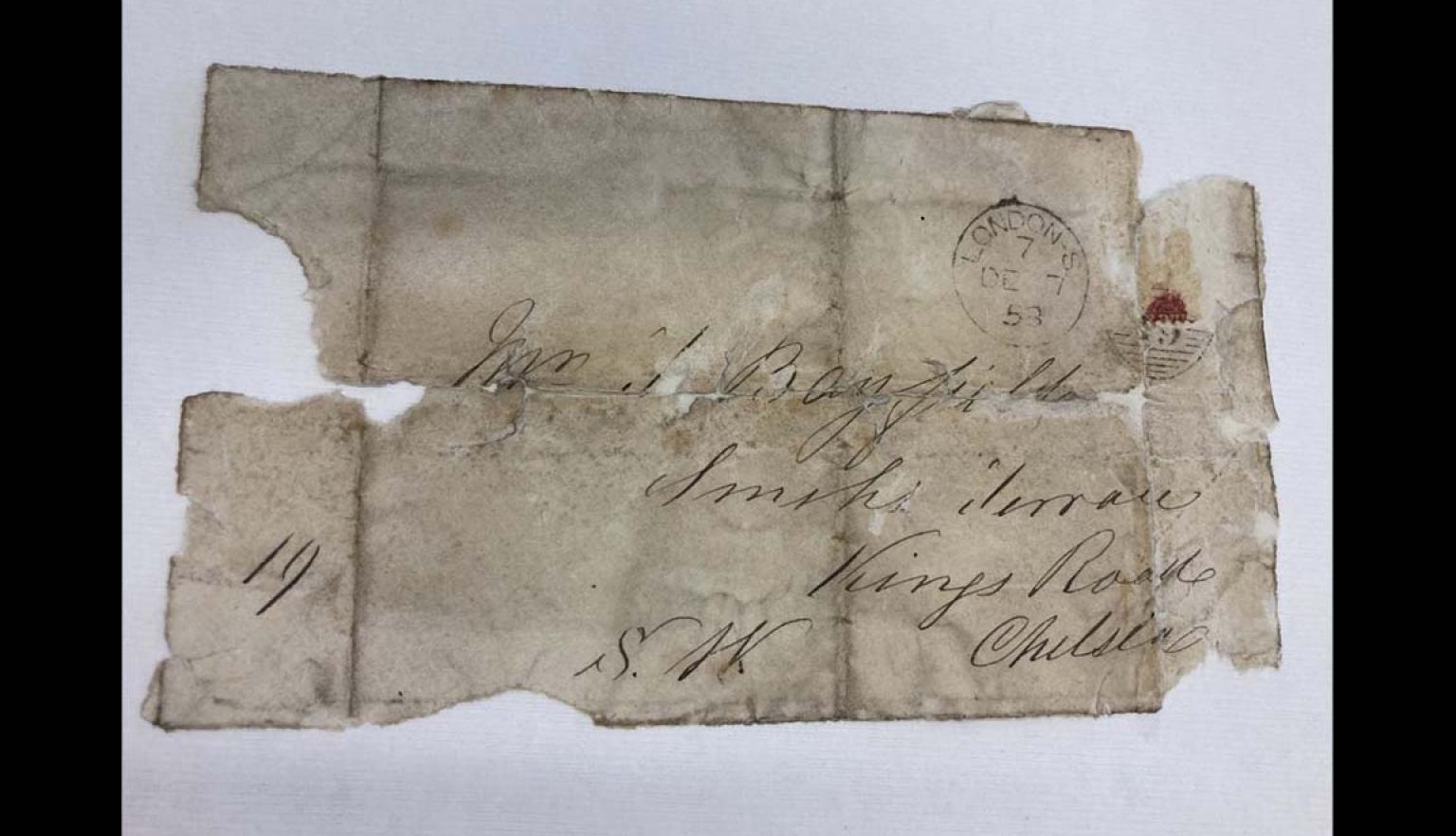 A worn letter with illegible writing and a stamp in the top right.