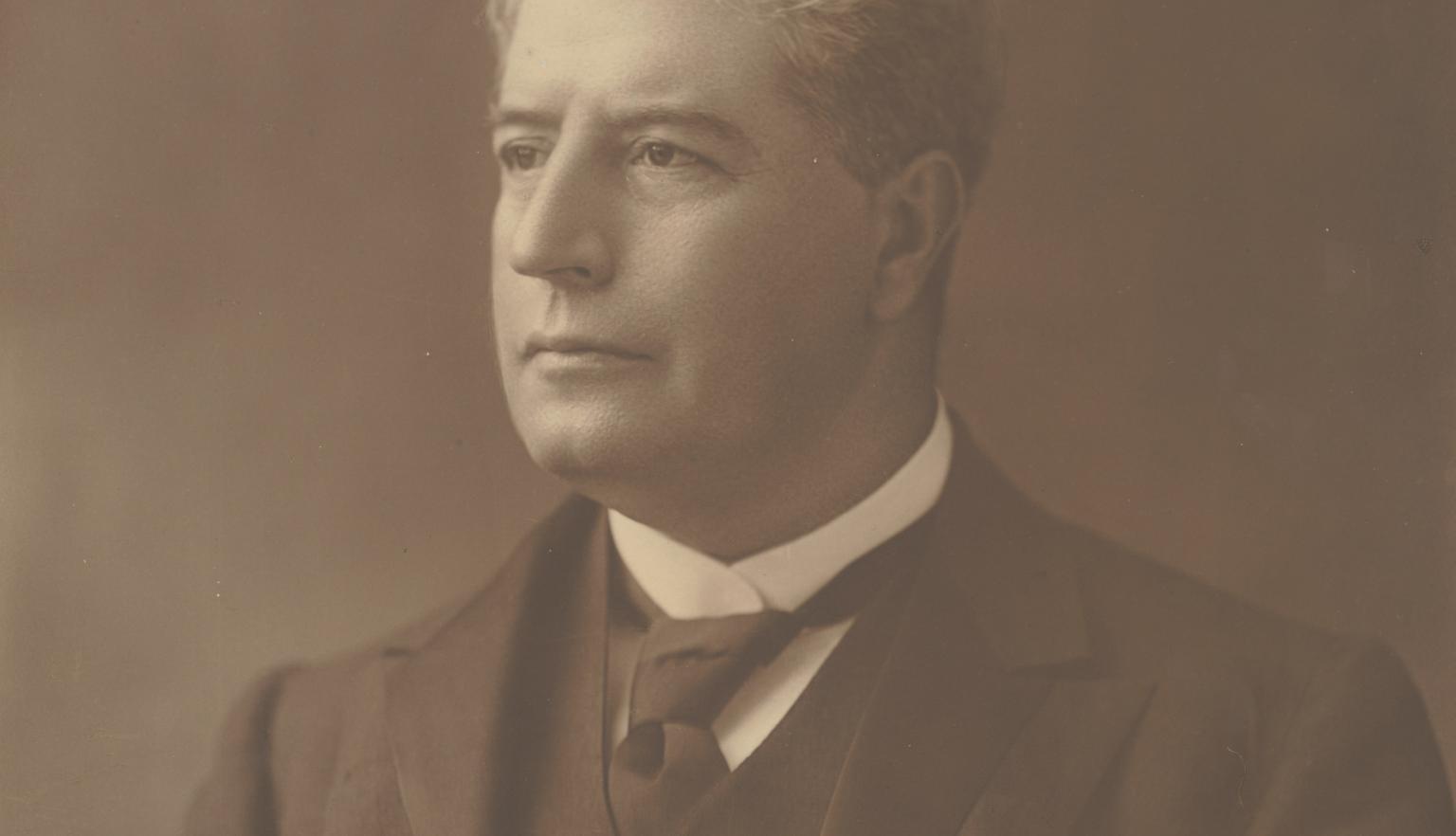 Portrait of a man with light, slightly wavy hair in a three piece suit