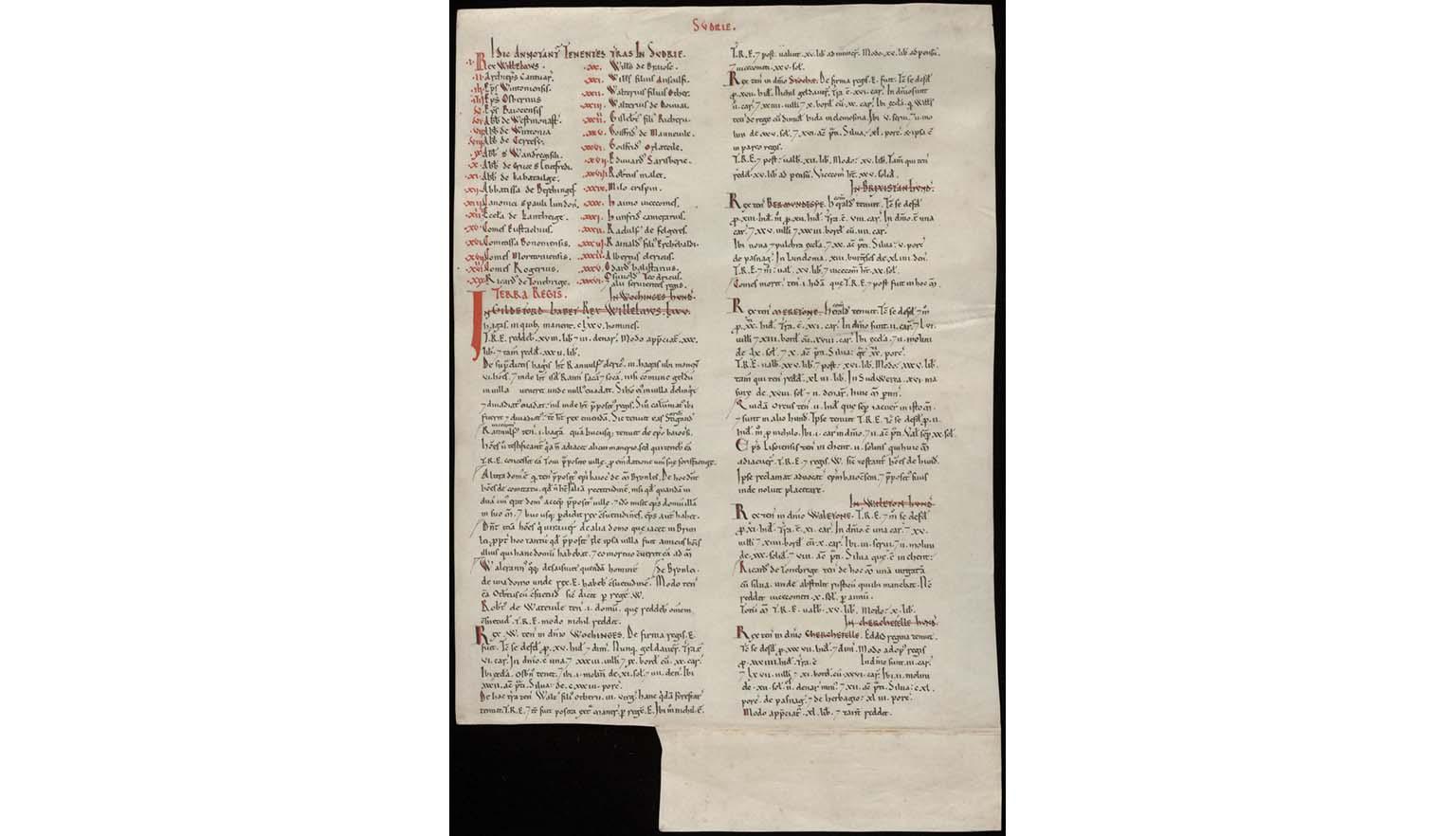 A facsimile copy of the Domesday Book. It is missing a square from the bottom left hand corner. Some of the text is black and some is red.