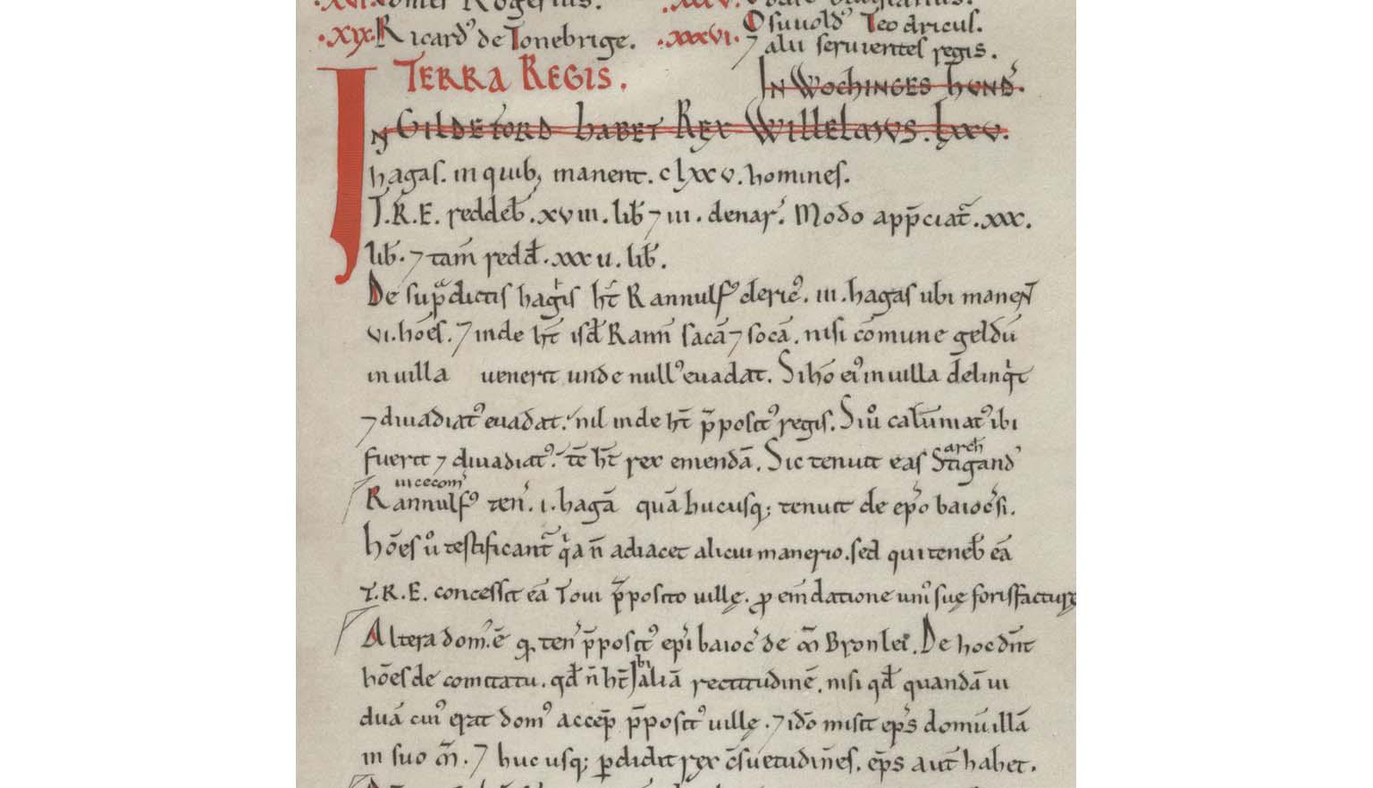 Inset from the Domesday Book. Most text is written in black ink. Some is in red. The words 'Terra Regis' is written prominantly in red. The document is written in Latin and lists land owned in the county of Surrey