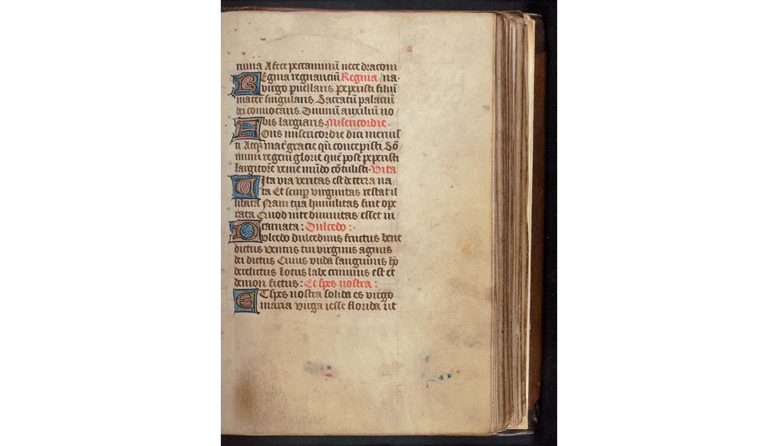 A handwritten page from a book of hours. The page is highly decorated and brightly coloured. 