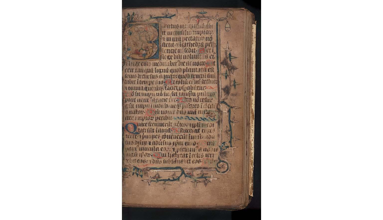 A very old document. It is handwritten. The text is in Latin and is written in black. The page is illuminated with stylised plants and vines. The first letter on the page is a "B". It is large and highly decorated.