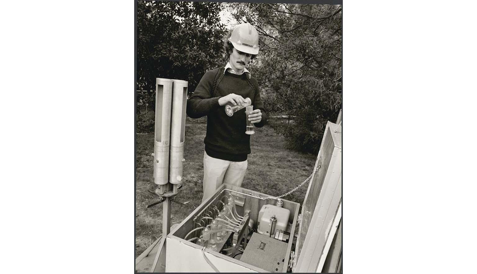 man in hardhat measuring using test tubes