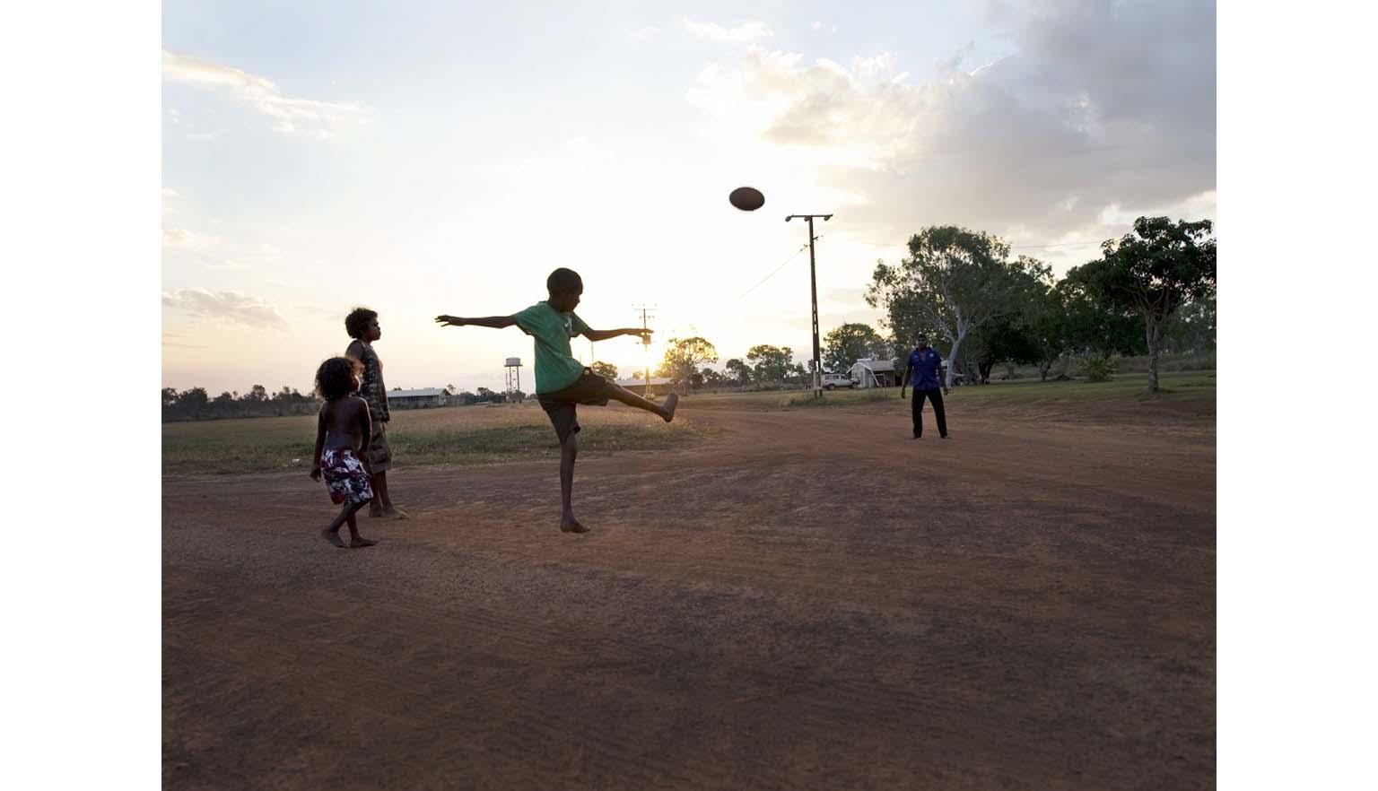 Photo of Aboriginal children playing football, Wudikapildiyerr outstation, Daly River, Northern Territory, 25 June 2010