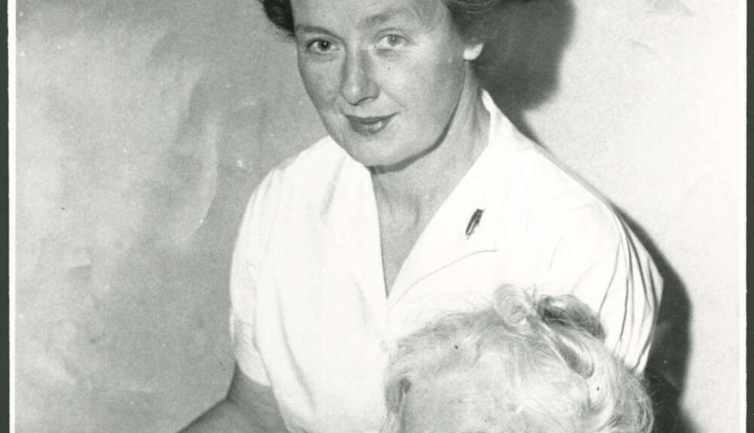 A younger woman standing and an older woman sitting using a radio
