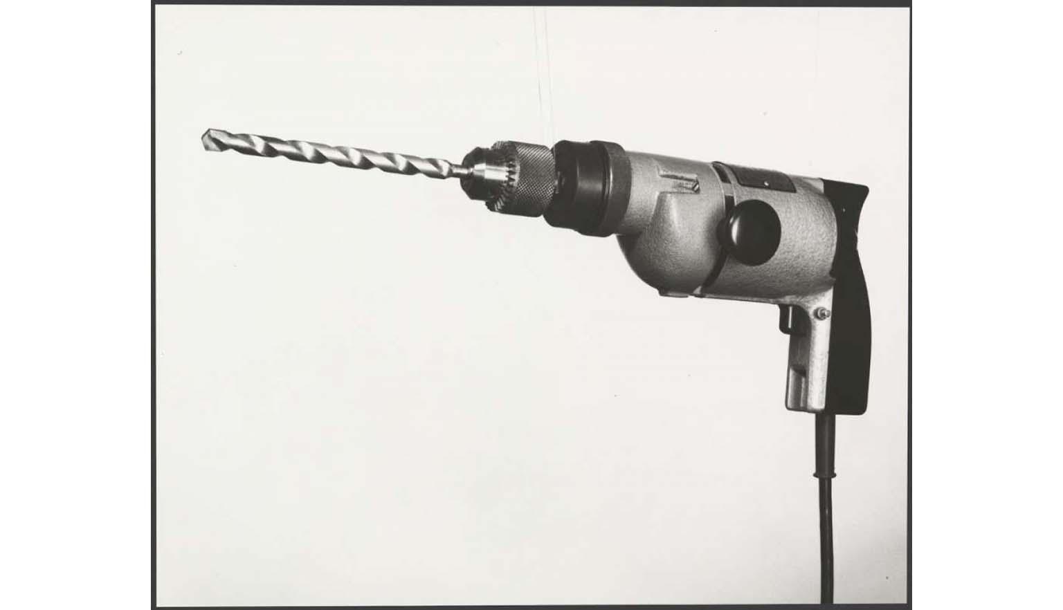 black and white photograph of an early electric drill