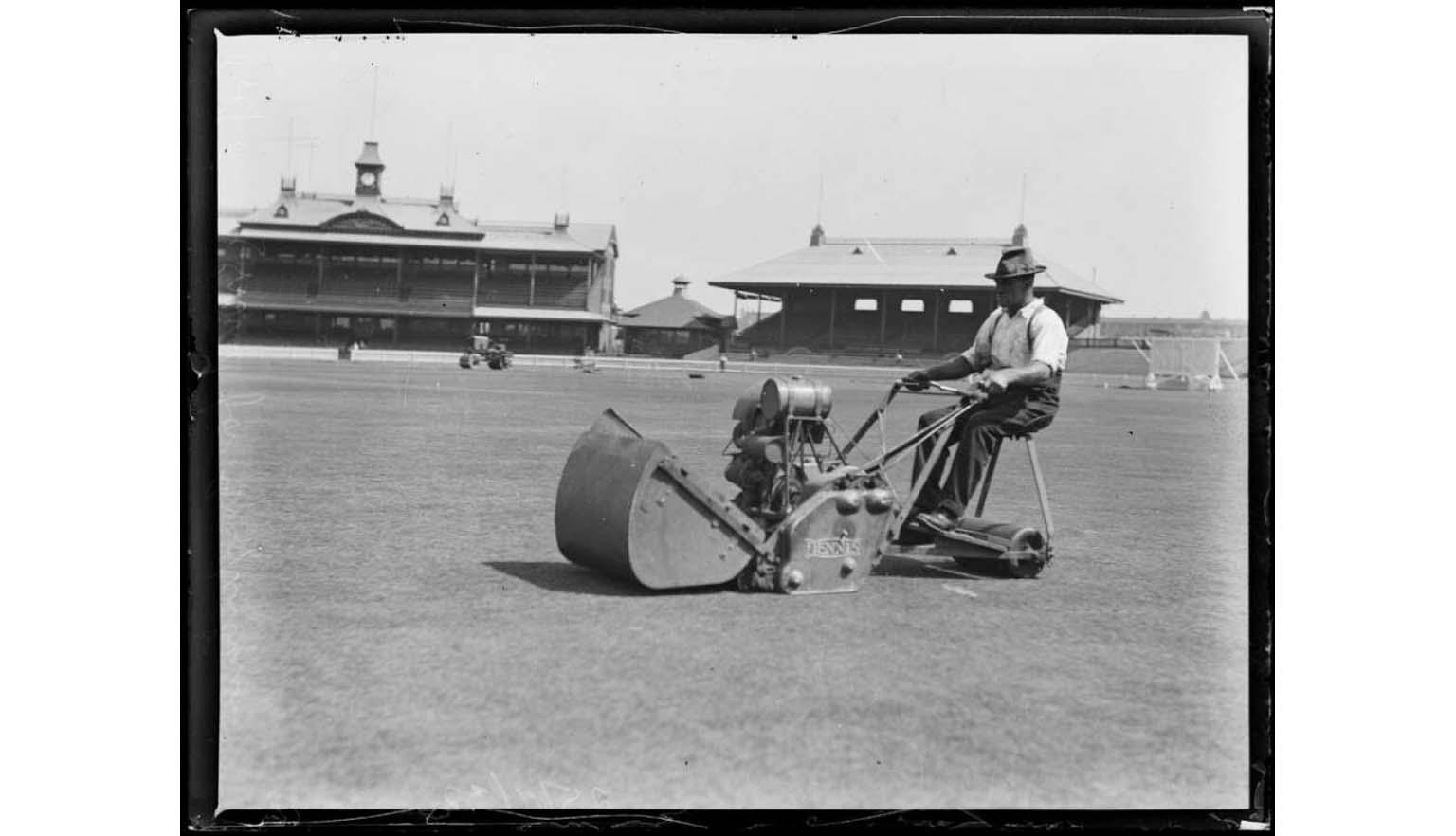 black and white photograph of a man mowing the lawn at the Sydney Cricket Ground