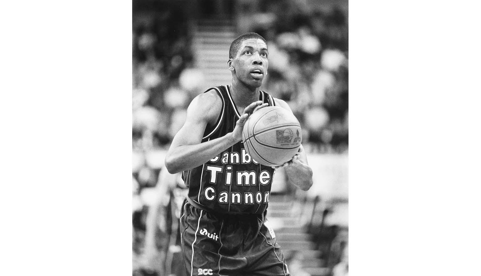 Black and white photo of basketball player, Robert Rose, poised to shoot at the goal