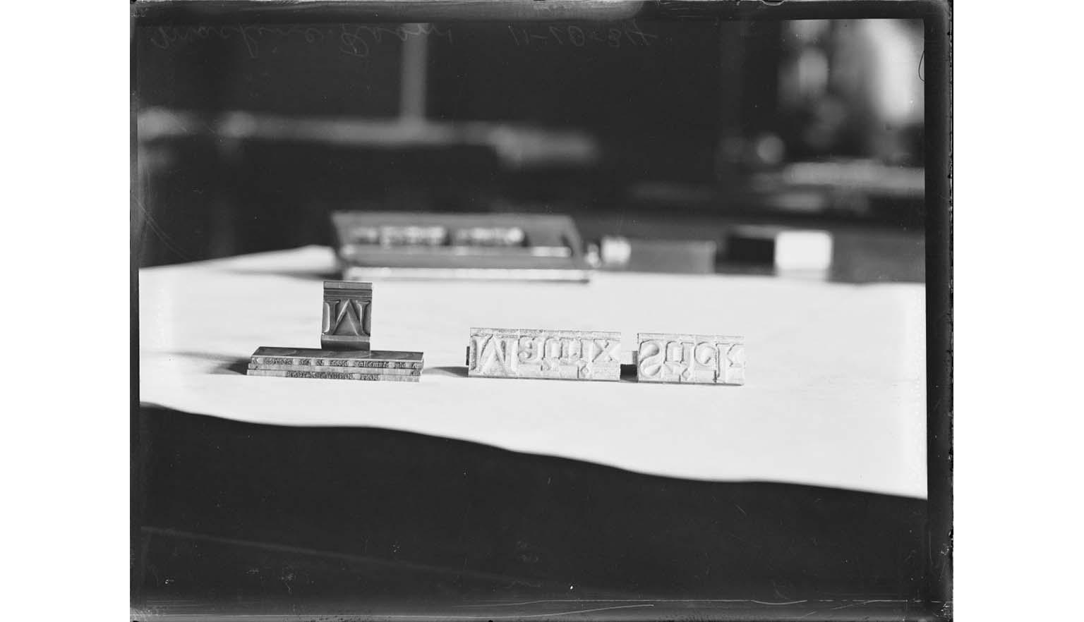 A black and white image of type letters on a piece of paper. The letters spell out "Matrix Stick" backwards and upside down.