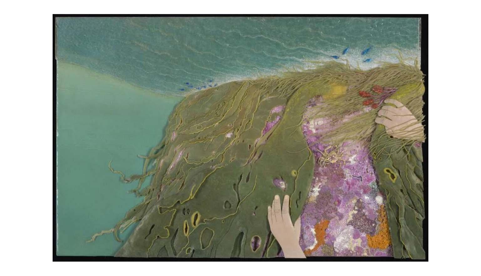 A child's hands move seaweed to reveal rocks