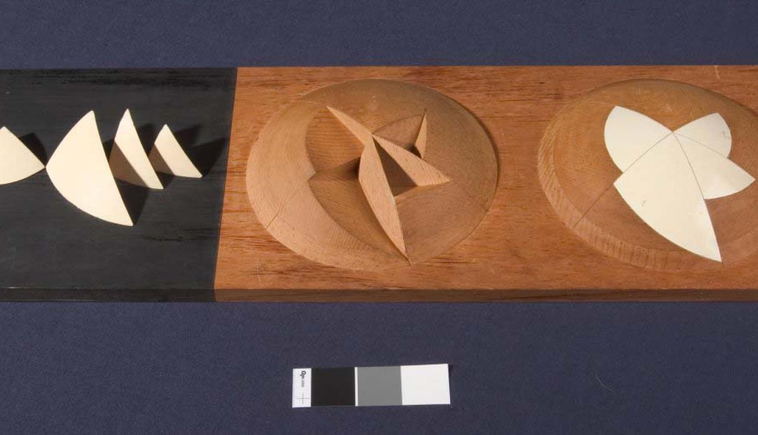 A stylised, abstract architects model of the Sydney Opera House. The model shows a hemisphere with triangular segments removed, another hemisphere shows the segments replaced to create a smooth surface.
