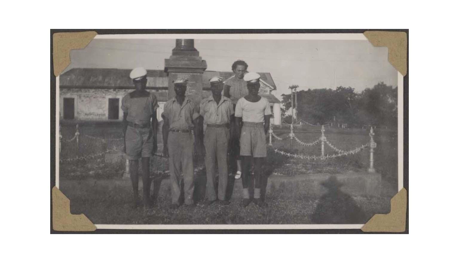 A group of Aboriginal men in military uniform stand outside a property